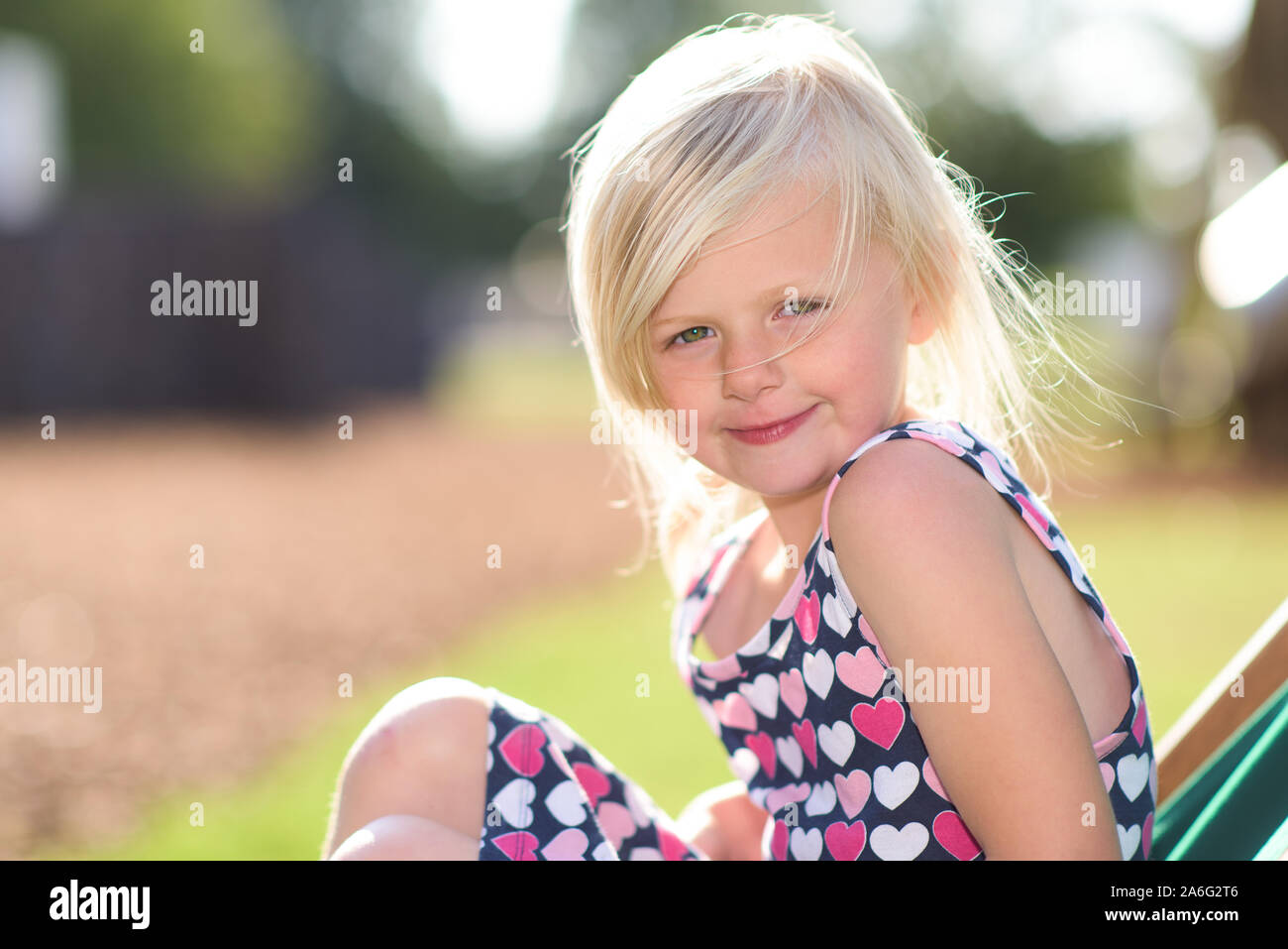 Ein hübsches kleines blondes Mädchen in die Kamera, während auf einer Brücke, starrt Stockfoto