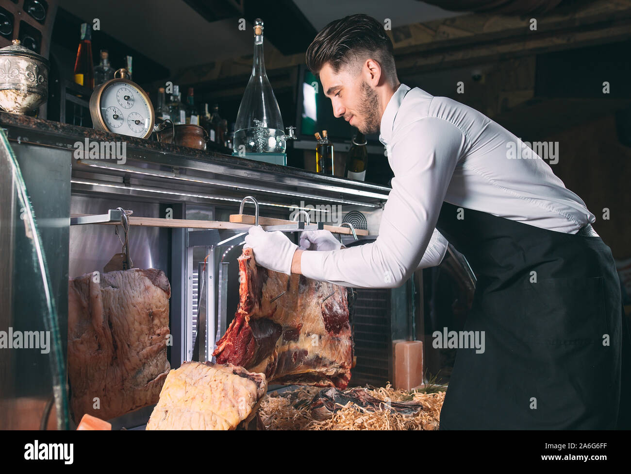 Der Kellner oder Koch erhält trockenes Fleisch im Kühlschrank Stockfoto