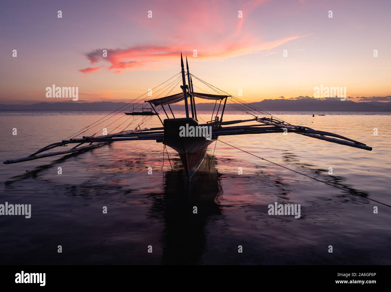 Sonnenuntergang und Fischerboot am Panagsama Beach, Moalboal, Cebu, Visayas, Philippinen. Stockfoto