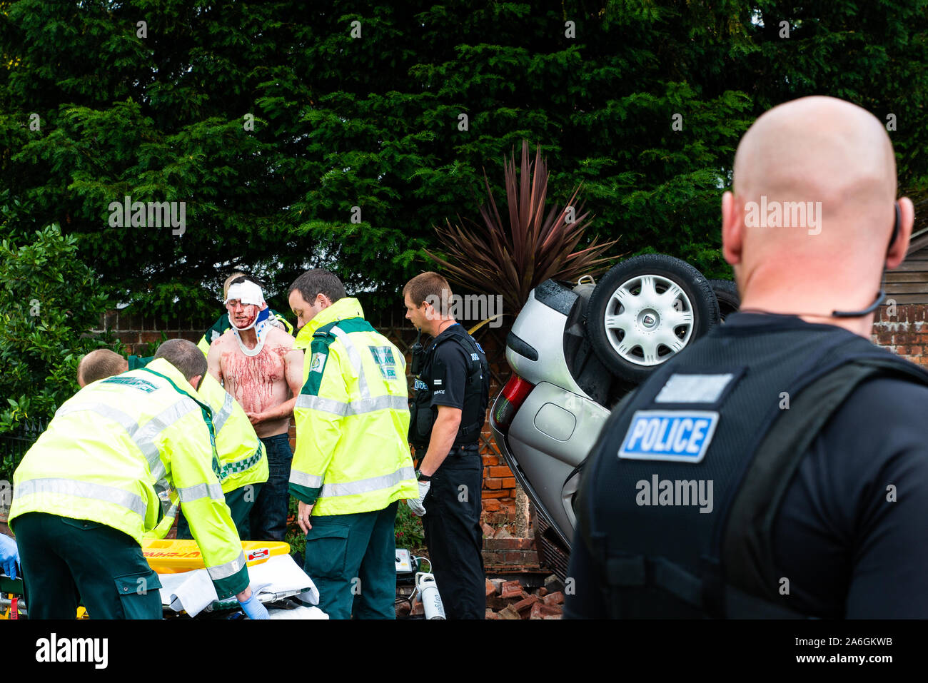 Die Notdienste über die Szene an einem Drink driving Unfall mit einer umgedreht und verletzten Fahrer, Polizei, Notarzt, Sanitäter und Feuerwehr, Polizei Stockfoto