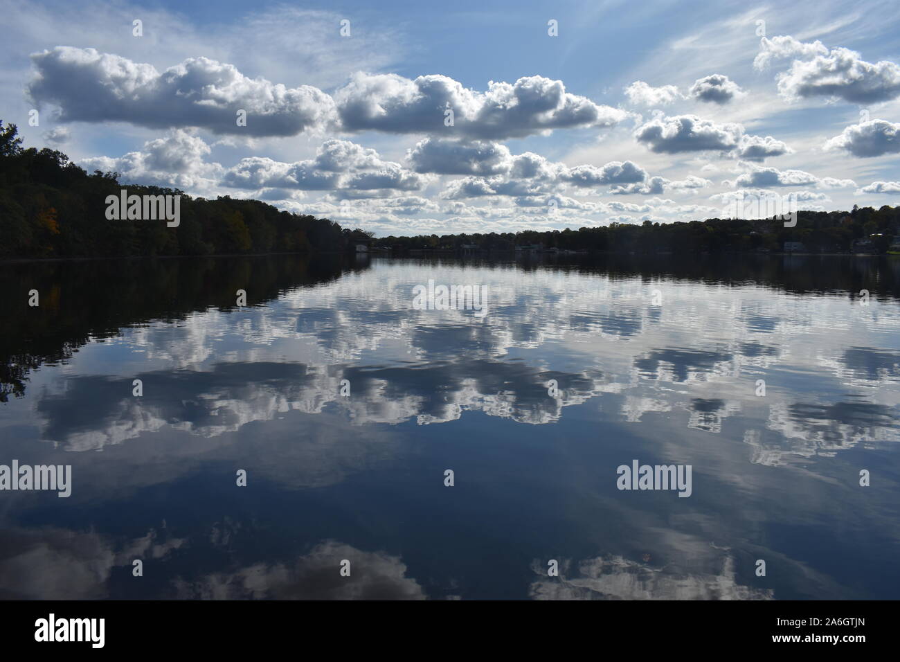 Eine leichte Brise sendet Wellen zu den ruhigen Wassern des mystischen See in Arlington, MA, mit reflektierenden cumulus Wolken über dem See Wasser. -02 Stockfoto