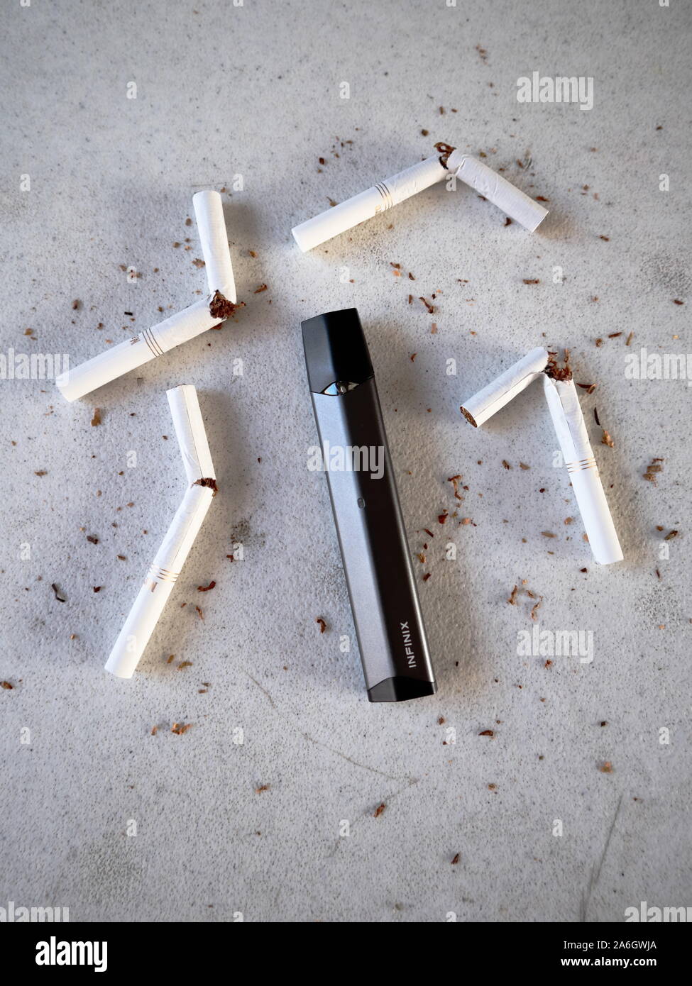 Vape Gerät Elektronische Zigarette smok infinix, wie Rauchen alternative mit gebrochenen Marlboro Gold Zigaretten und Tabak auf weiße strukturierte Bac Stockfoto