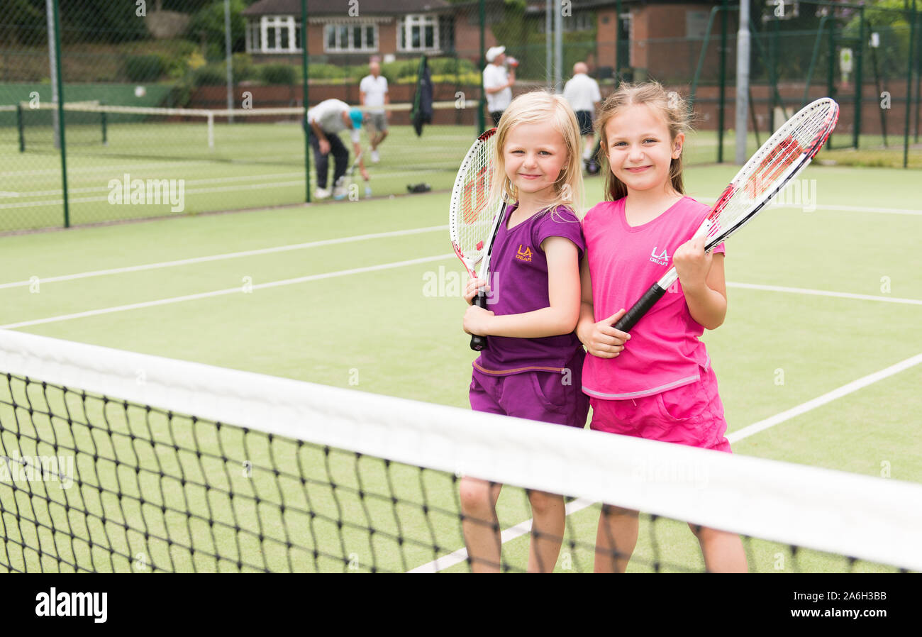 Zwei junge Mädchen üben Ihre Tenniskünste auf lokaler Tennis Club, Hof Stockfoto