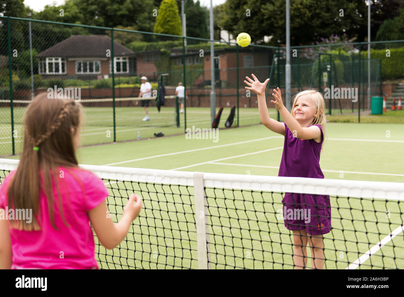 Zwei junge Mädchen üben Ihre Tenniskünste auf lokaler Tennis Club, Hof Stockfoto