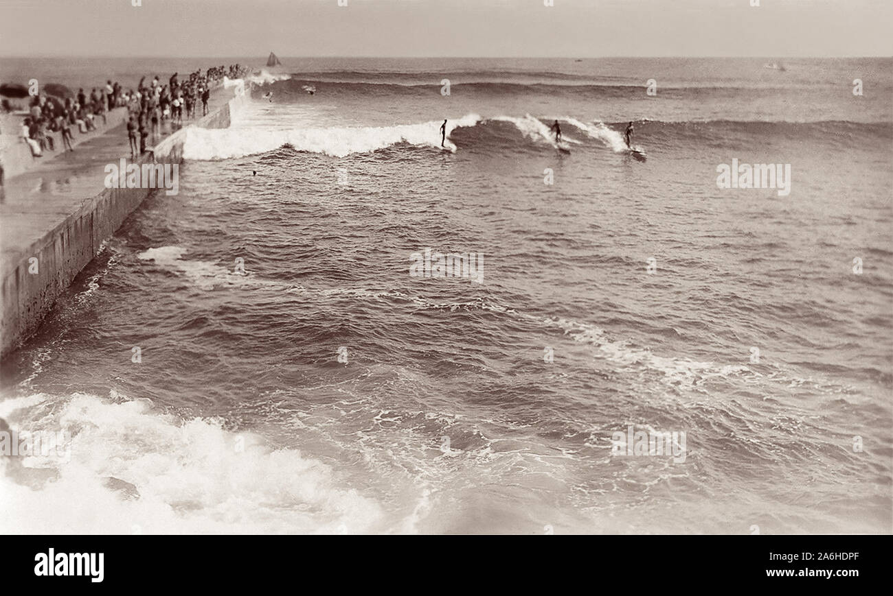 Surfer reiten große Wellen c 1930s/1940s entlang der Kalifornischen Corona Del Mar Mole, direkt neben dem weltberühmten Surf spot nun als Keil in Newport Beach bekannt. Stockfoto