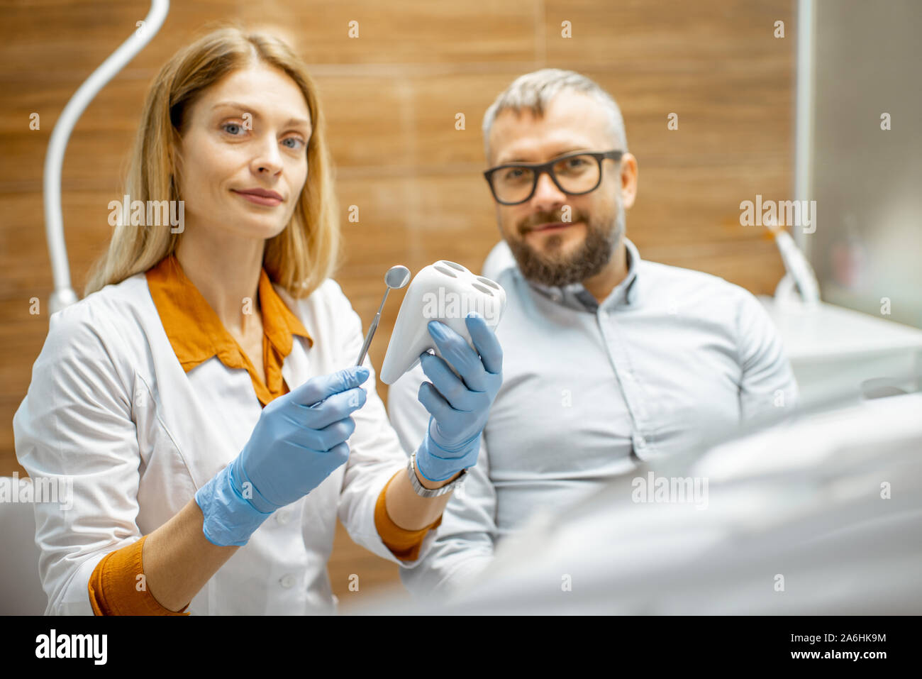 Portrait einer weiblichen Zahnarzt mit Zähnen Modell und gutaussehenden Mann wie ein Patient während einer medizinischen Beratung in der Zahnarztpraxis Stockfoto