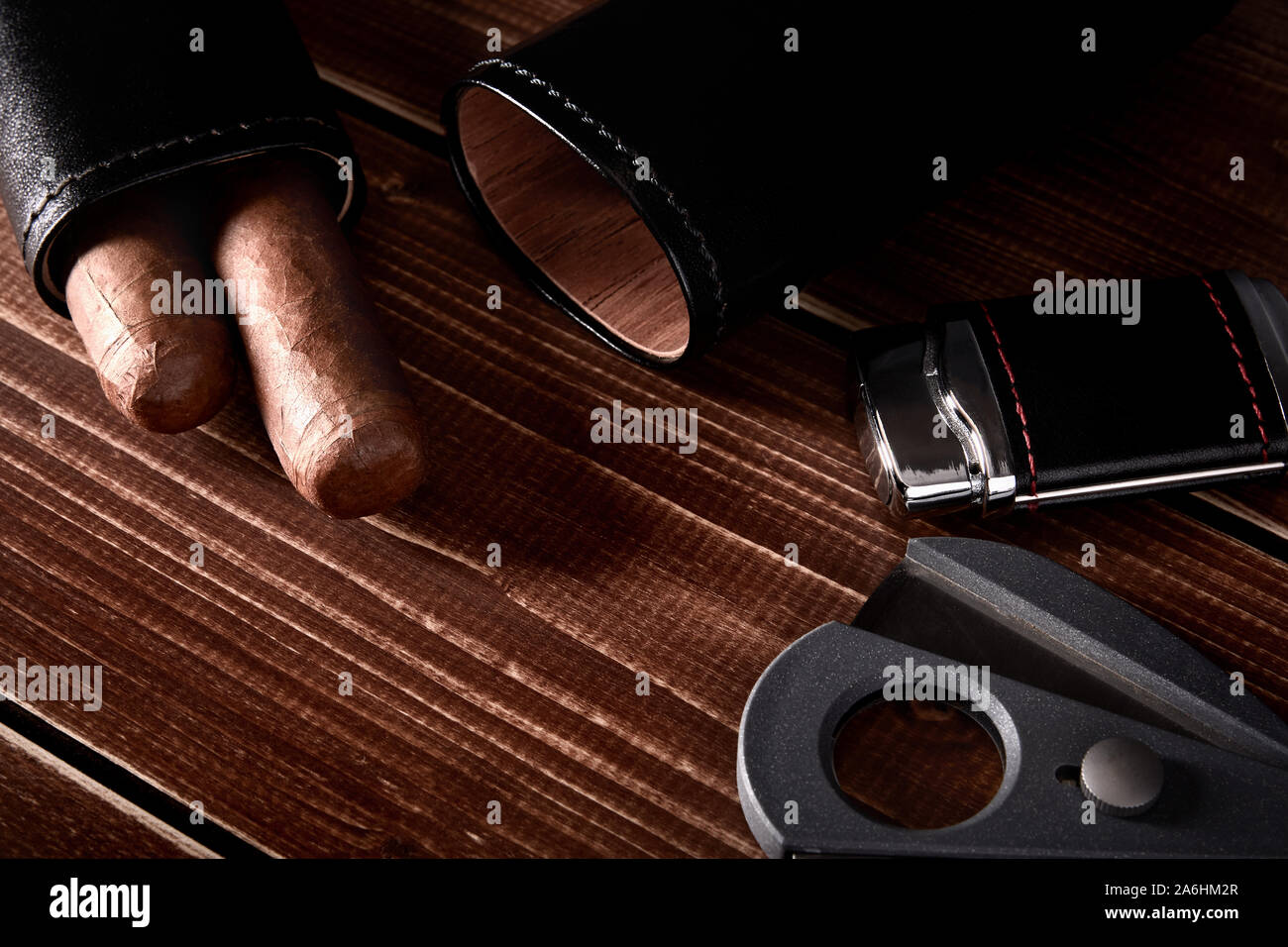 Stillleben mit kubanischen Zigarren in schwarze Ledertasche, Cutter und leichter auf alten hölzernen Tischplatte mit Platz für Text Stockfoto