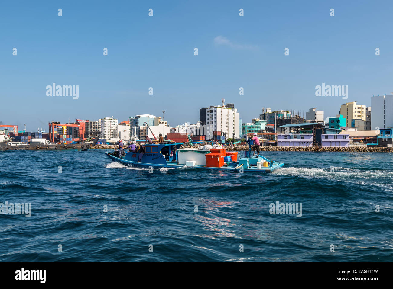 Male, Malediven - November 18, 2017: Transport Boot segeln im Meer auf dem Hintergrund der Insel der Männlichen. Waterfront Stadtbild der männlichen Stadt als se Stockfoto