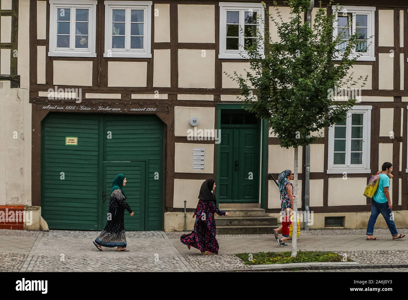 Muslimische Frauen zu Fuß entlang der alten Stadt Gebäude sind in Kyritz, Brandenburg, Deutschland am 1. August 2019 © Michal Fludra/Alamy Live Nachrichten gesehen Stockfoto