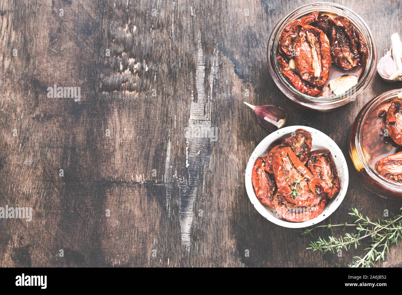 Sonnengetrocknete Tomaten mit Olivenöl in einem Glas auf Holz- Hintergrund. Stockfoto