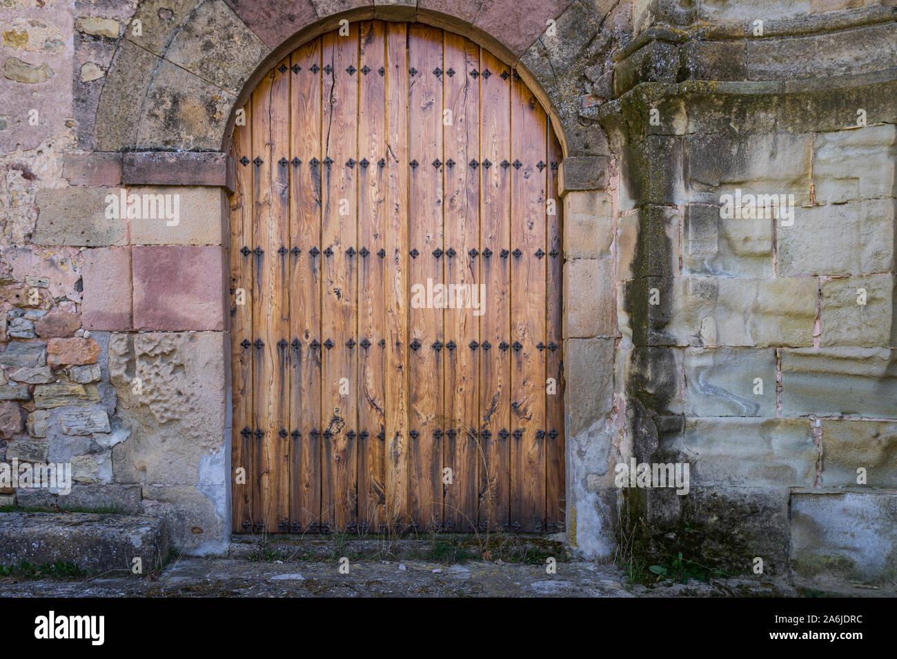 Alte braune Holztür mit Rundbogen in eine romanische Kirche in Siguenza, Spanien Stockfoto Alte braune Holztür mit Rundbogen in eine romanische Kirche in Siguenza, Spanien Stockfoto