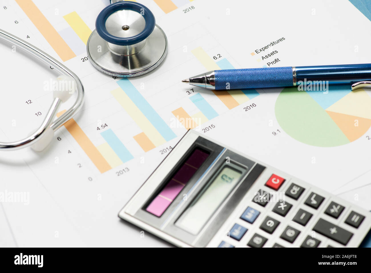 Stethescope, Stift und Taschenrechner mit finanziellen Diagramme und Berichte medizinische Konzept zu veranschaulichen. Stockfoto