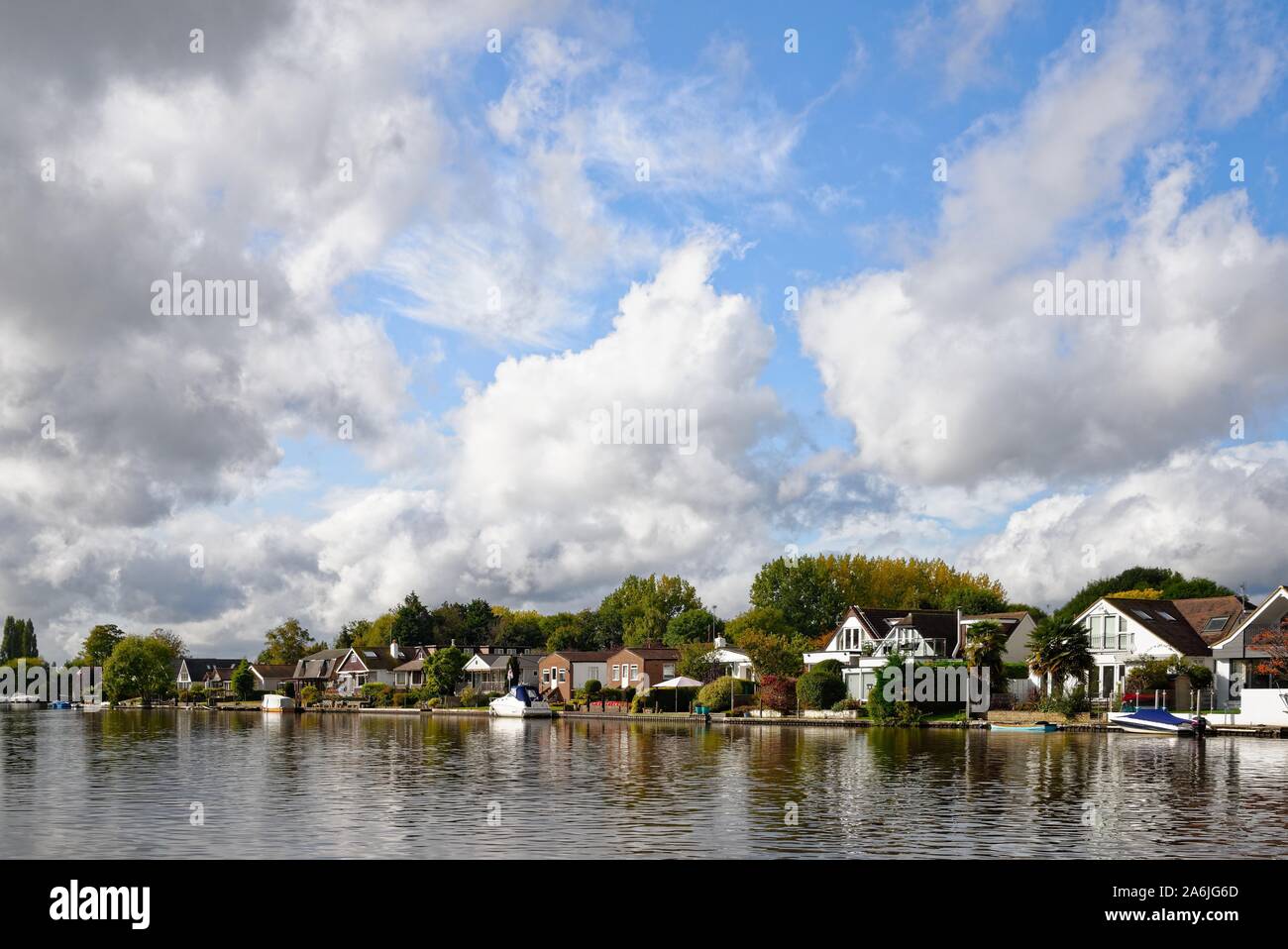 Waterside private Häuser am Flussufer in Sunbury on Thames gegen einen dramatischen Wolkenbildung, Surrey, England, Großbritannien Stockfoto