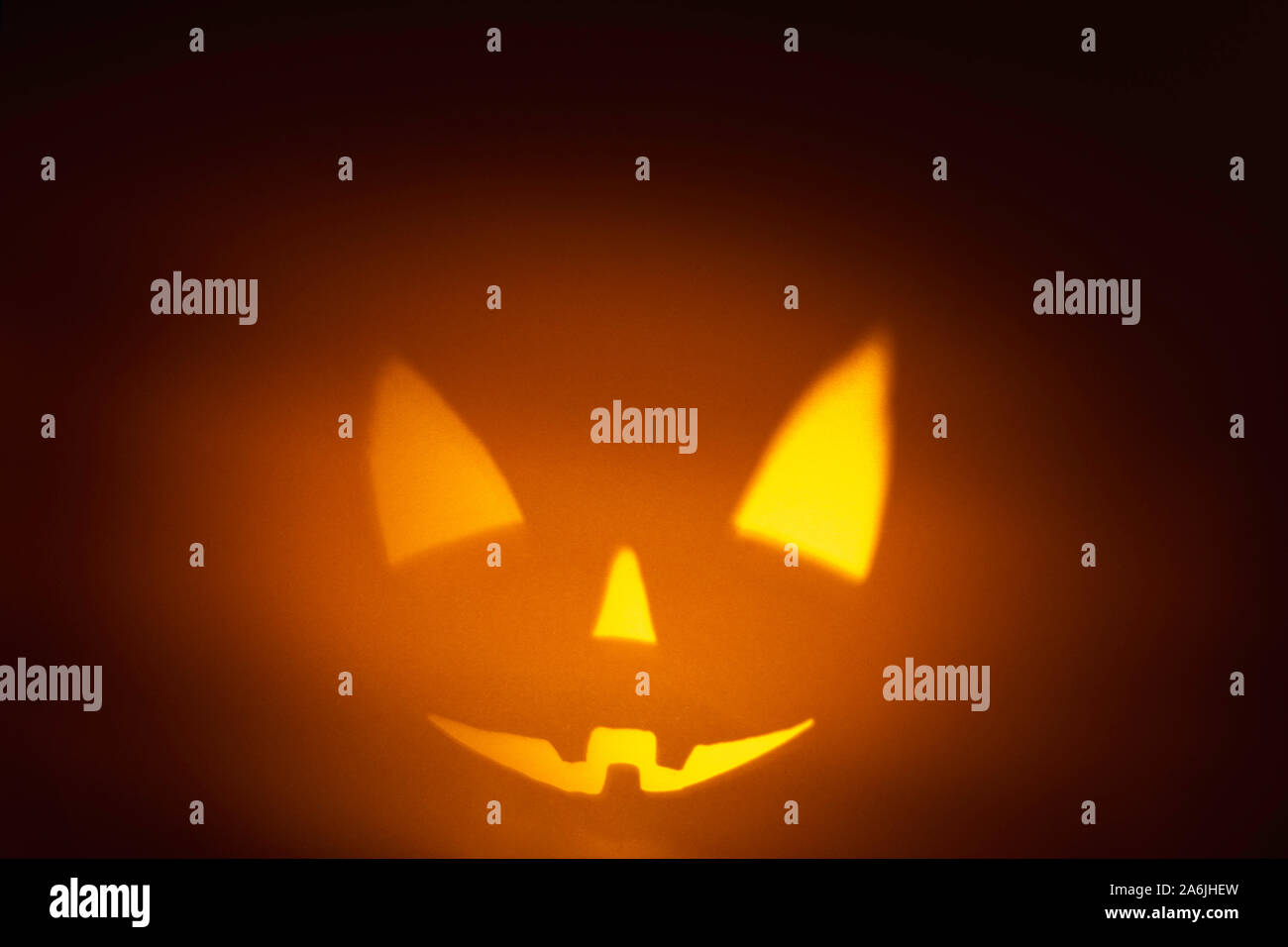 Charakter halloween scary pumpkin Gesicht auf dunklen orange Papier Hintergrund. Beängstigend, Lächeln, Gesicht. Halloween Horror Hintergrund Stockfoto