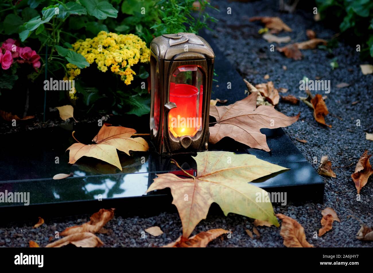 Grab Licht in Abendstimmung auf einem Friedhof mit Blätter im Herbst Stockfoto