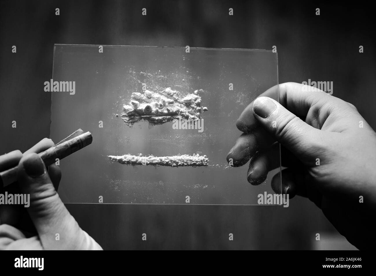 Kokain oder Speed in einer Linie. Süchtiger mit Euro Rechnung für snorting, Drogenmissbrauch Konzept close-up Schwarz und Weiß Stockfoto