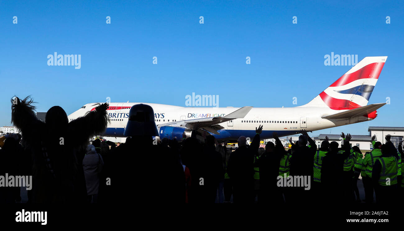 Mitarbeiter und Gäste Welle aus einem eigens gecharterten British Airways Jet voller Kinder in ganz Großbritannien vom Heathrow Flughafen als Teil der Dreamflight liebe Reise nach Florida. Stockfoto