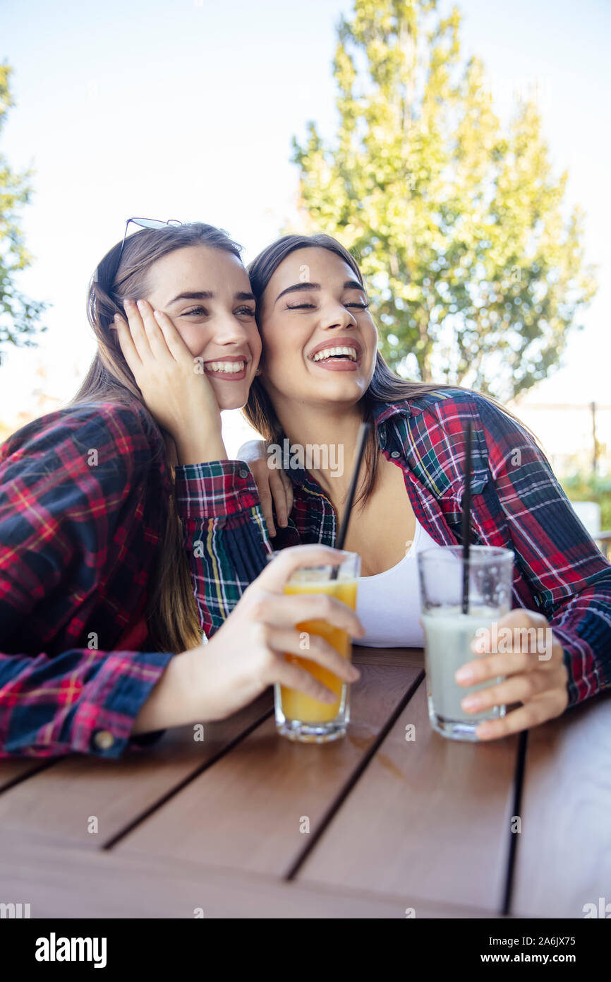 Zwei junge Frauen trinken Saft und Limonade in den Park an einem sonnigen Tag Stockfoto