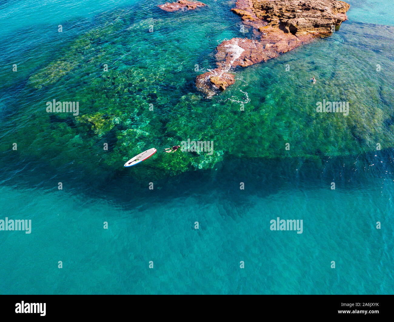 Luftaufnahme von einem Paddle Board im Wasser schwimmend auf einem transparenten Meer, Schnorcheln. Badende am Meer. Tropea, Kalabrien, Italien. Tauchen Entspannung Stockfoto