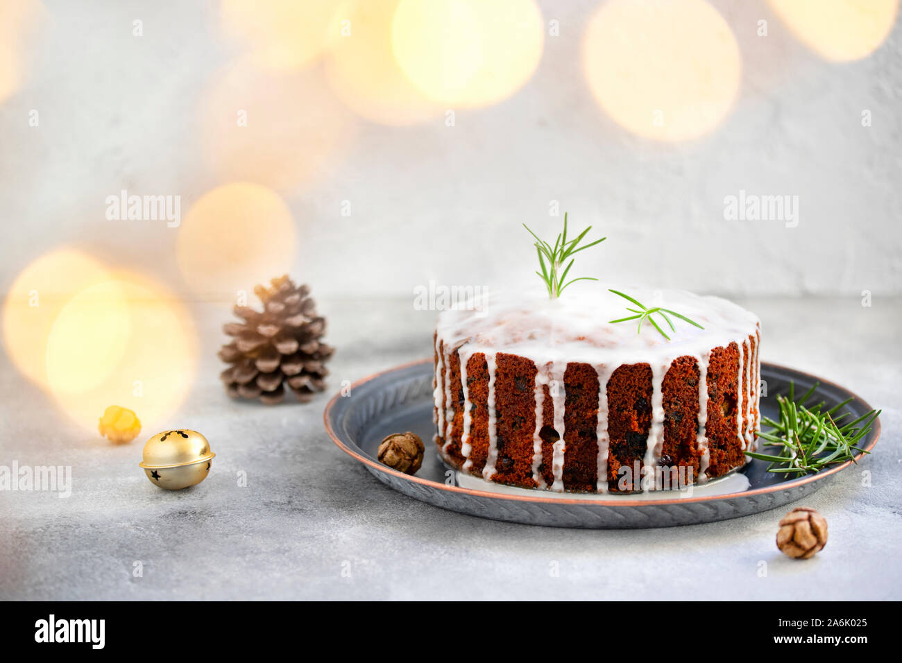 Traditionelle Weihnachtskuchen mit Früchten und Nüssen vor einem hellen Hintergrund. Dessert für den Winterurlaub. Weihnachten Dekorationen und Lichter Stockfoto