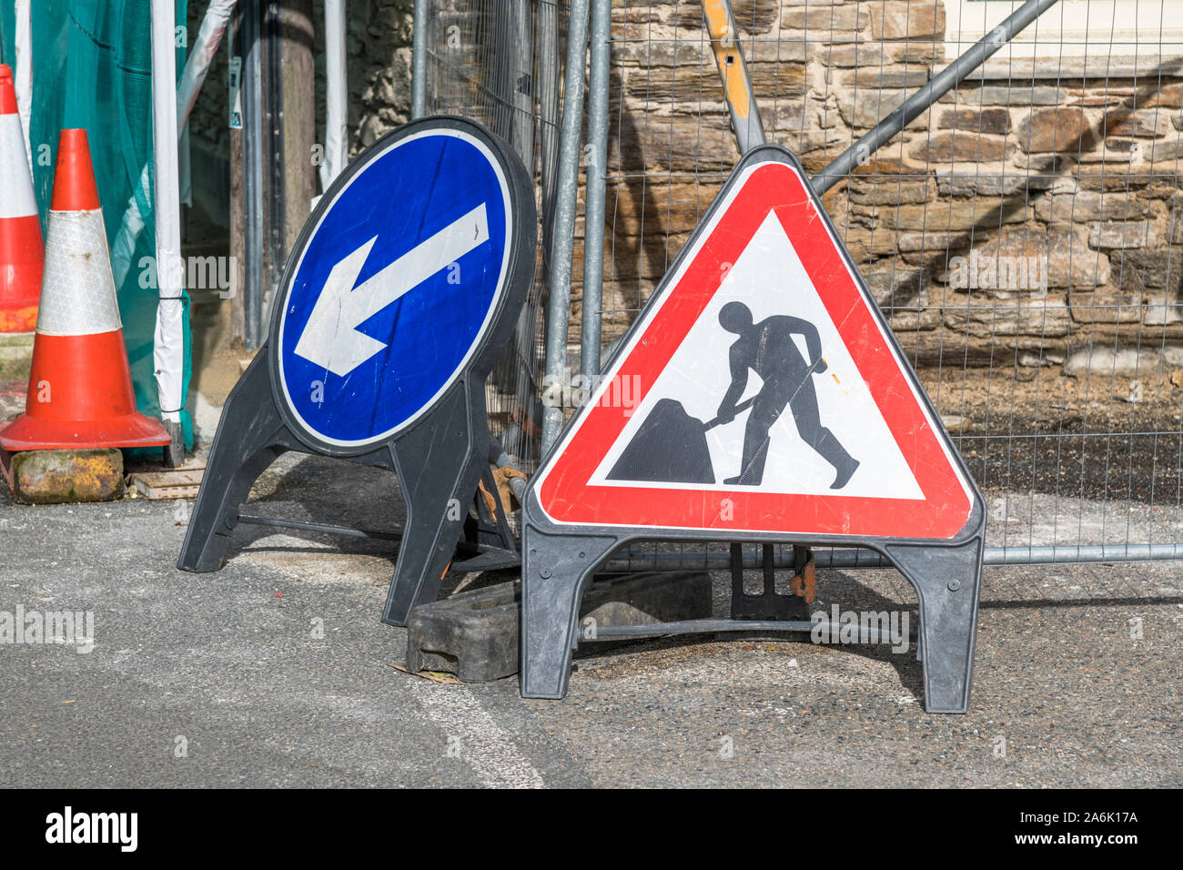 Mann bei der Arbeit Piktogramm Baustellen Zeichen in der Stadt von Looe, Cornwall, mit blauen linken Pfeil, der Verkehr Richtung unterzeichnen. Bis zu graben. Stockfoto