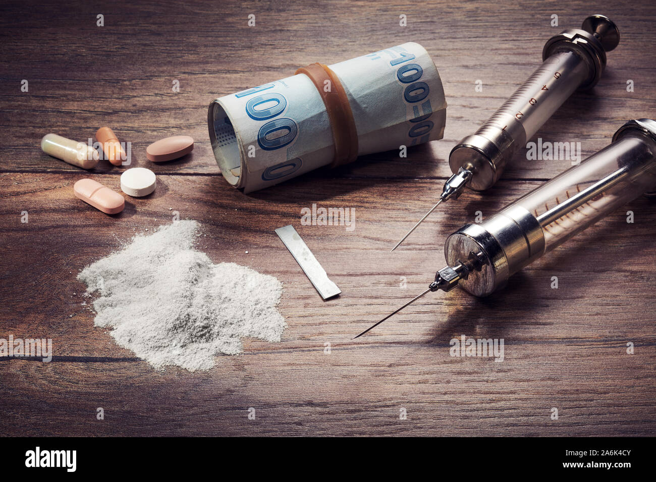 Vintage spritzen, Kokain, Pillen und rollte Türkische Lira, Rechnungen auf Holztisch. Konzept der Drogenabhängigkeit und des Drogenhandels. Stockfoto