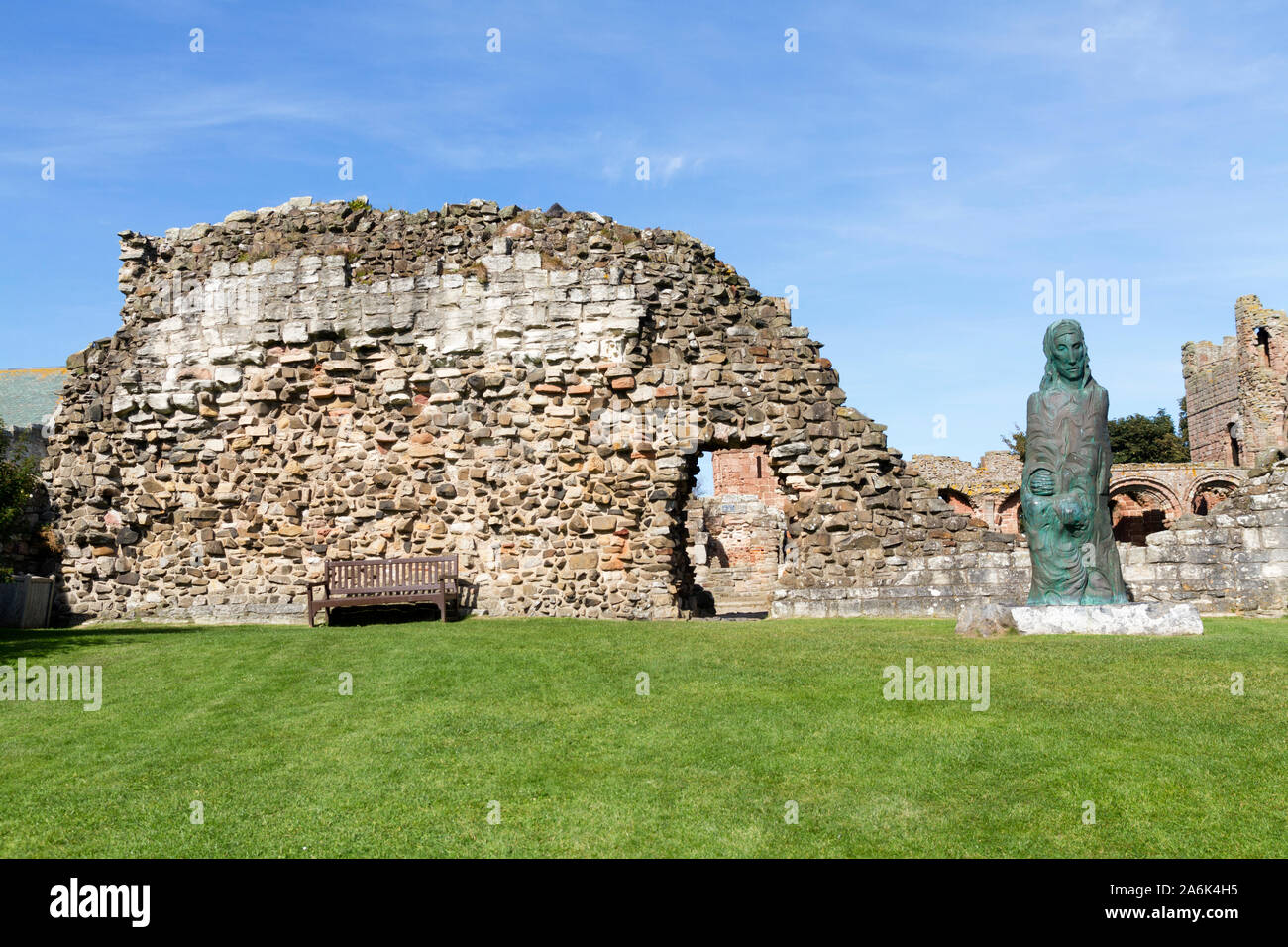 Die Statue von Cuthbert der Farne in den Ruinen von Lindisfarne Priory auf Holy Island, Northumberland, Großbritannien Stockfoto