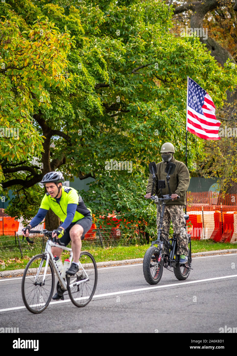 New York, USA, 26. Oktober 2019. Ein Mann auf einem Camouflage Kostüm trägt eine US-Flagge auf seinem Fahrrad, vielleicht Halloween feiern, in New York City's C Stockfoto