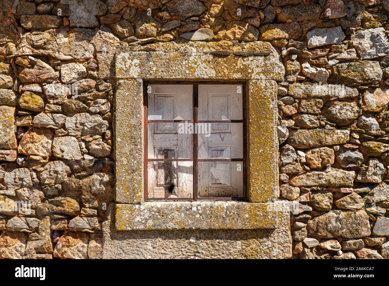 Gebrochene Glasscheibe und Fensterläden aus Holz in Stein Fenster und Wand des alten Hauses in der antiken Stadt Castelo Rodrigo in Portugal Stockfoto