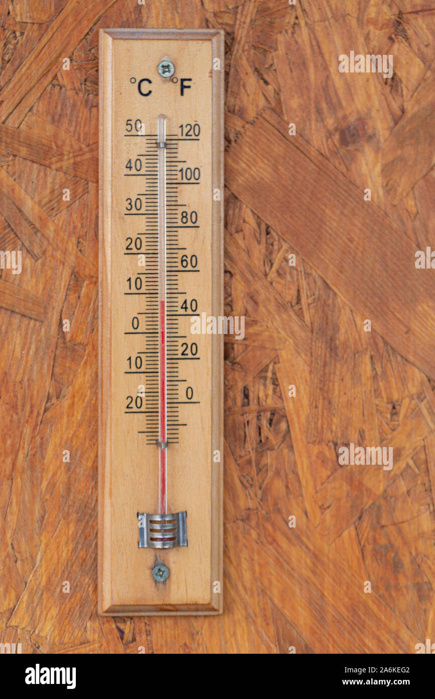 Wärme Temperatur Thermometer auf der hölzernen Wand außerhalb des Hauses Stockfoto