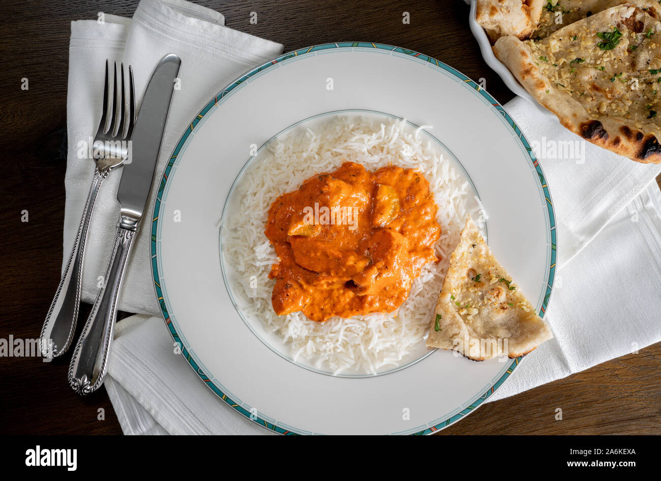 Chicken Tikka Masala mit Knoblauch Naan Brot auf weiße Platte auf Serviette und von oben genommen Stockfoto