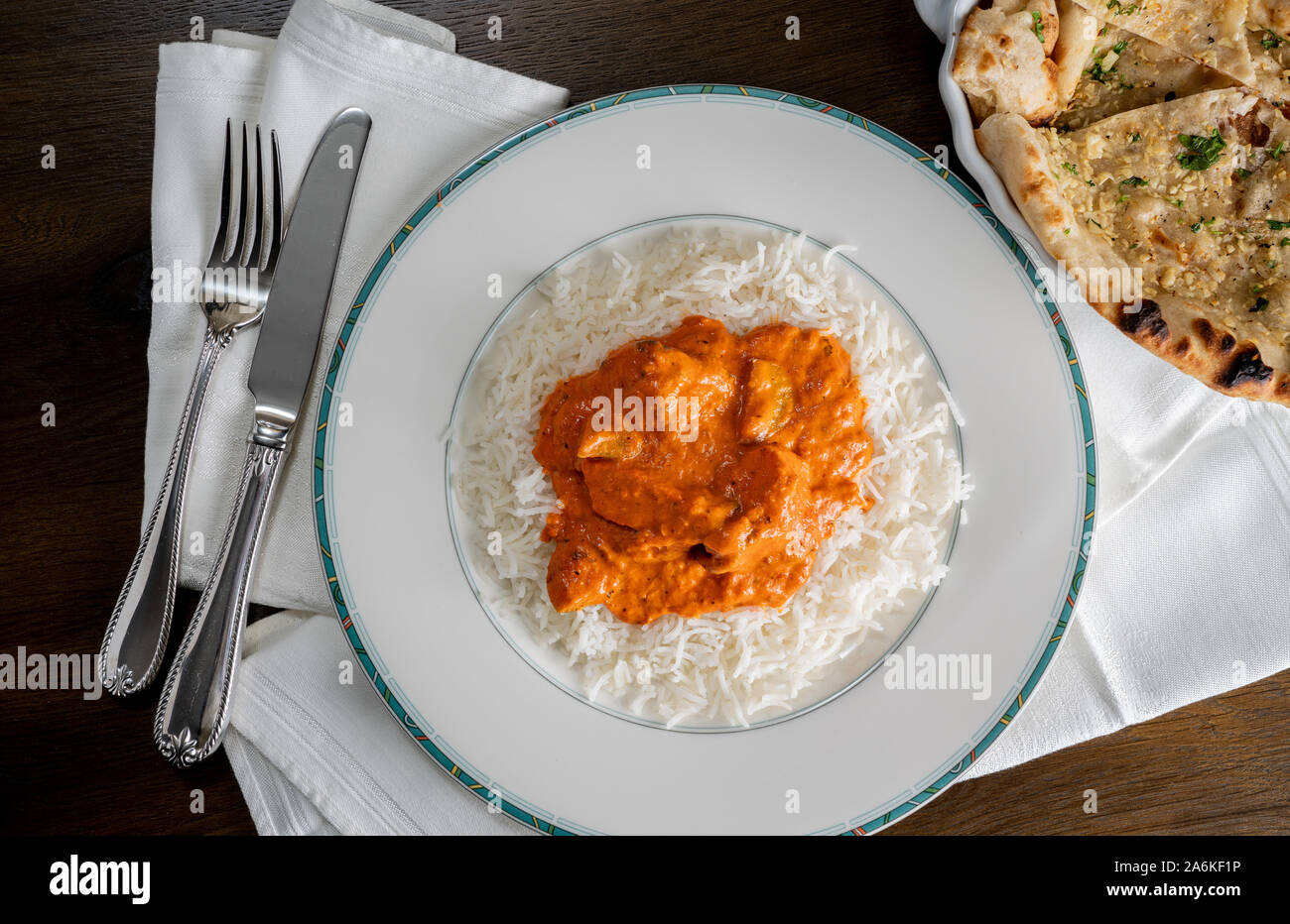 Chicken Tikka Masala mit Knoblauch Naan Brot auf weiße Platte auf Serviette und von oben genommen Stockfoto