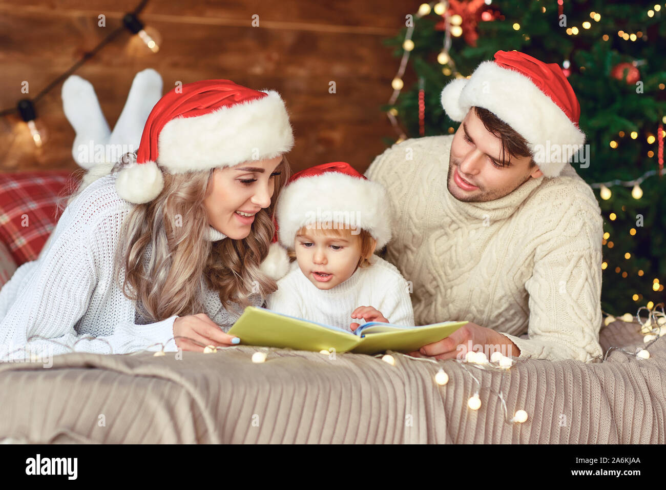 Happy Family liest ein Buch zu Weihnachten. Stockfoto