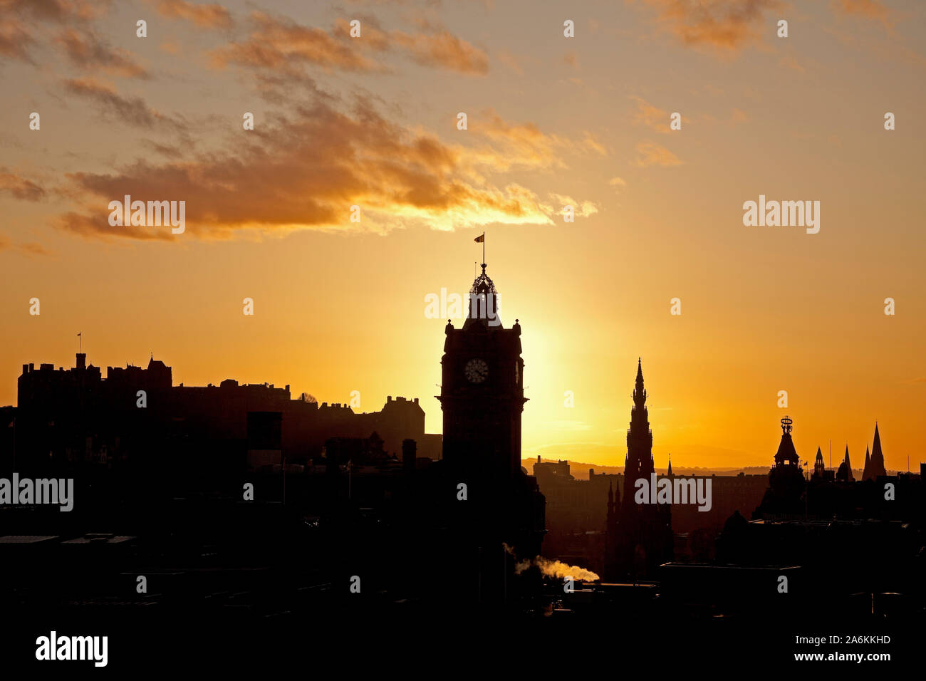 Calton Hill, Edinburgh, Großbritannien. 27. Oktober 2019. UK Wetter. Farbenfroher Sonnenuntergang über der Innenstadt eine Silhouette des Schlosses mit Scott Monument und Balmoral Hotel Clock Tower, einem kühlen 10 Grad. Stockfoto