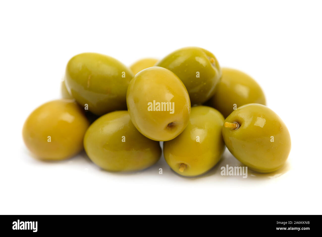 Stapel von nassen grüne Oliven in Salzlake makro Tropfen auf weißem Hintergrund Stockfoto