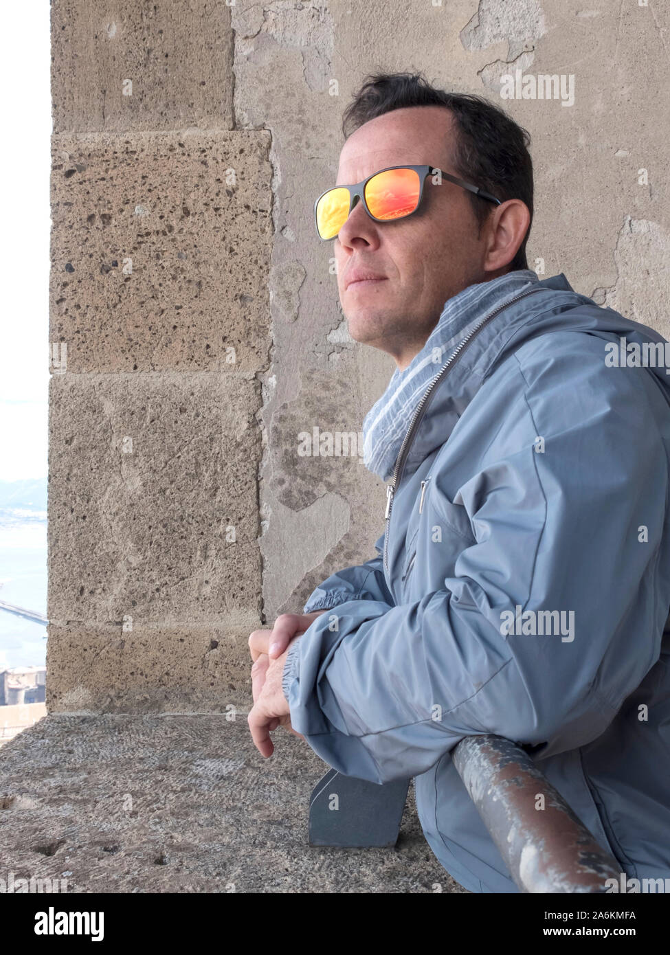 Nachdenklicher Mann mit Sonnenbrille stützte sich auf eine historische Fenster nach draußen Stockfoto