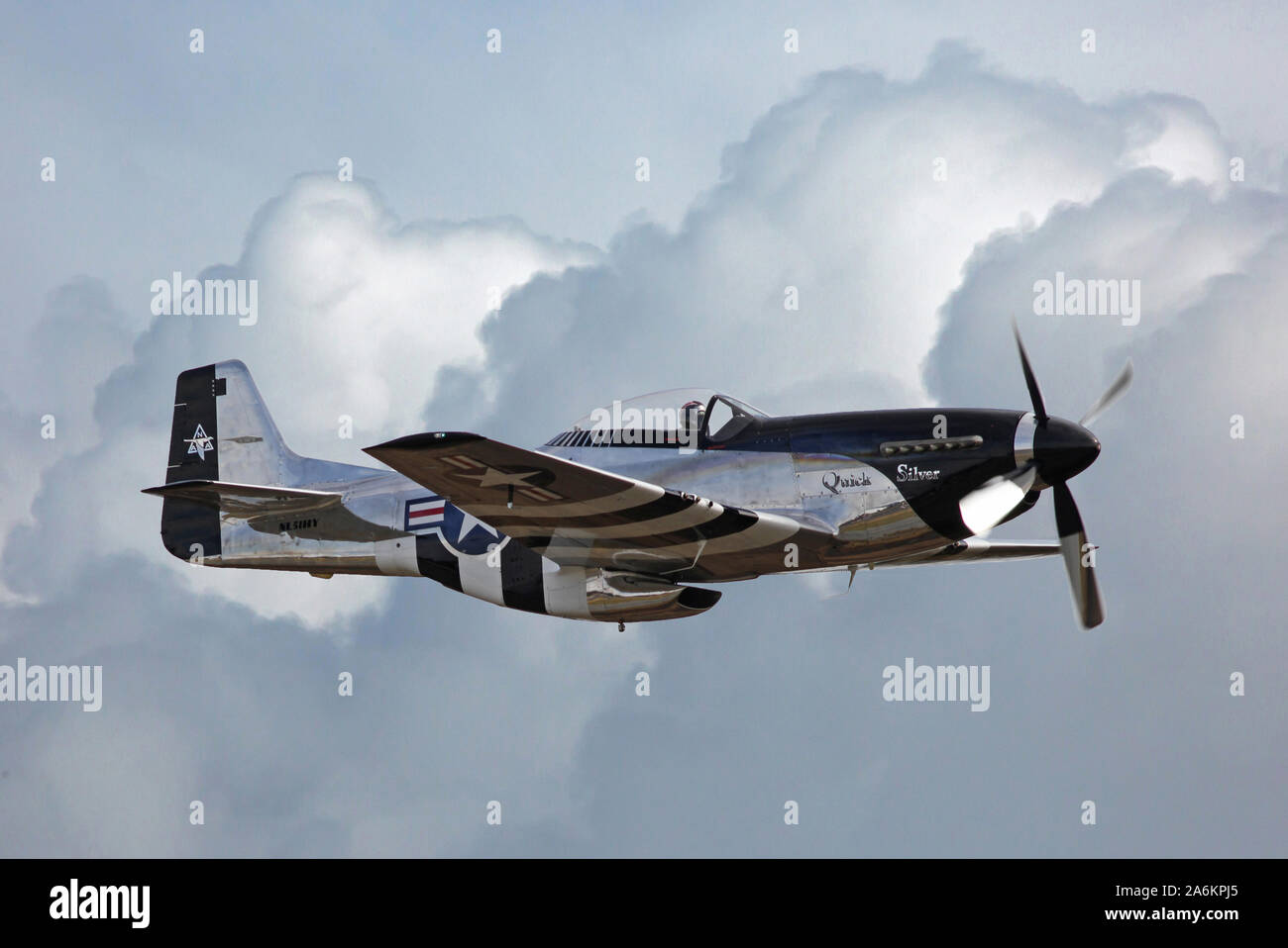 Ein aus der Zeit des Zweiten Weltkriegs P-51 Mustang Jagdflugzeug fliegt durch wogende Gewitterwolken. Stockfoto