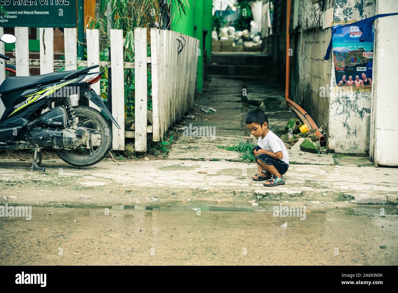 Ein Kind, das außerhalb seiner Familie shop in El Nido, Philippinen. Stockfoto