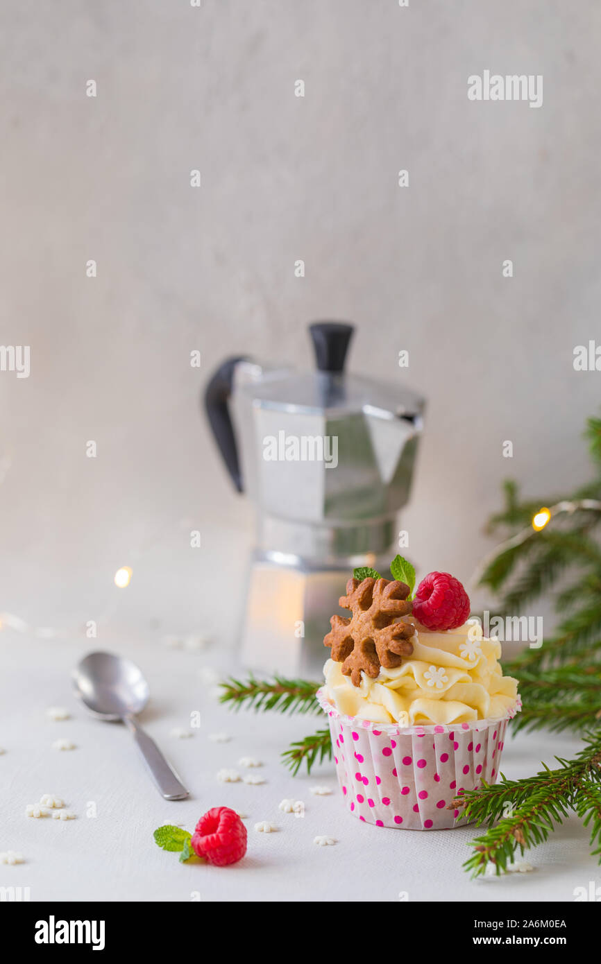 Weihnachten kleine Kuchen oder Muffins mit Sahne und Himbeere, über die Fir Tree Branches Hintergrund, getönt Stockfoto