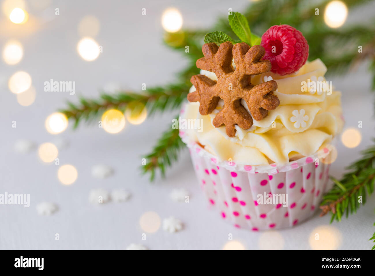 Weihnachten kleine Kuchen oder Muffins mit Sahne und Himbeere, über die Fir Tree Branches Hintergrund, getönt Stockfoto