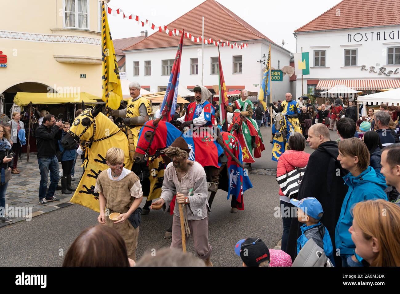Ritter reiten Pferde mit bunten caparison und Banner von der Öffentlichkeit auf dem Mittelalterfest Eggenburg, Österreichs größte mittelalterliche Veranstaltung beobachtete Stockfoto