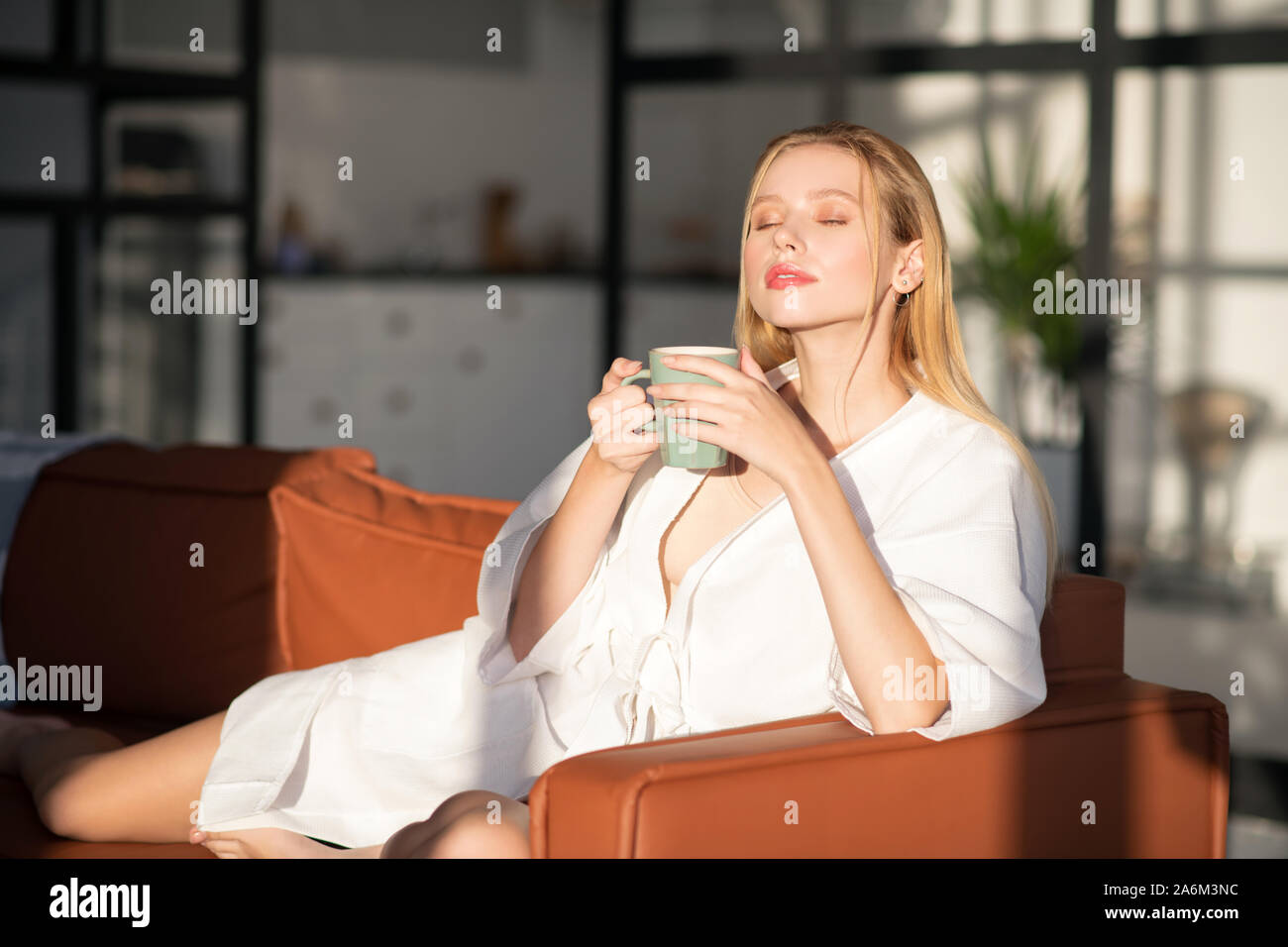 Blonde Frau riechen nur gebrühten Kaffee am Morgen Stockfoto