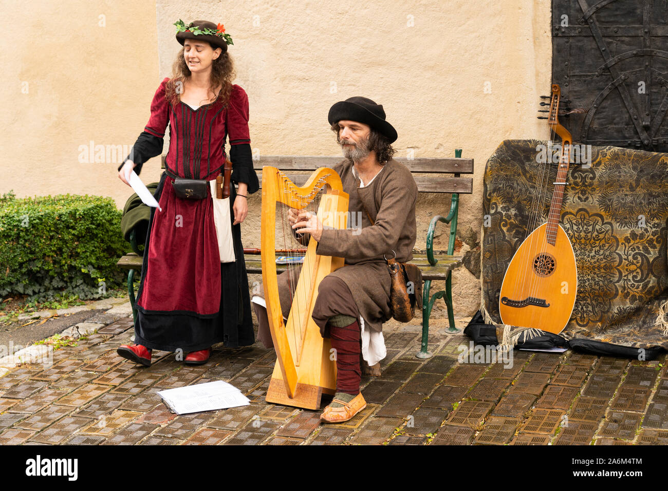 Ein Mann und eine Frau in mittelalterlichen Kleidern spielen eine Harfe und Gesang an der beliebten Mittelalterfest Eggenburg, Österreichs größte mittelalterliche Veranstaltung Stockfoto