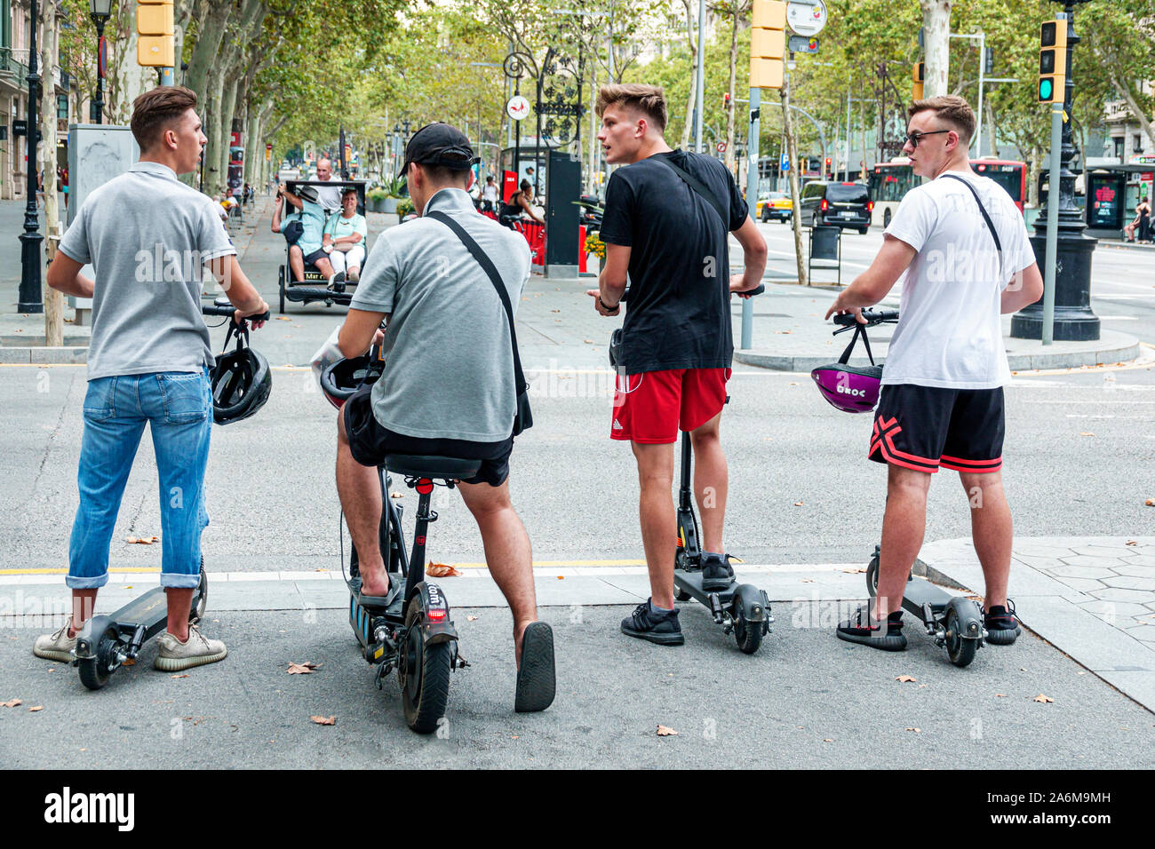 Barcelona Spanien, Katalonien Passeig de Gracia, Einkaufsviertel, breiter Bürgersteig, Straßenkreuzung, Mann, Freunde, junge Erwachsene, elektrische Step-Roller, warten auf Stockfoto