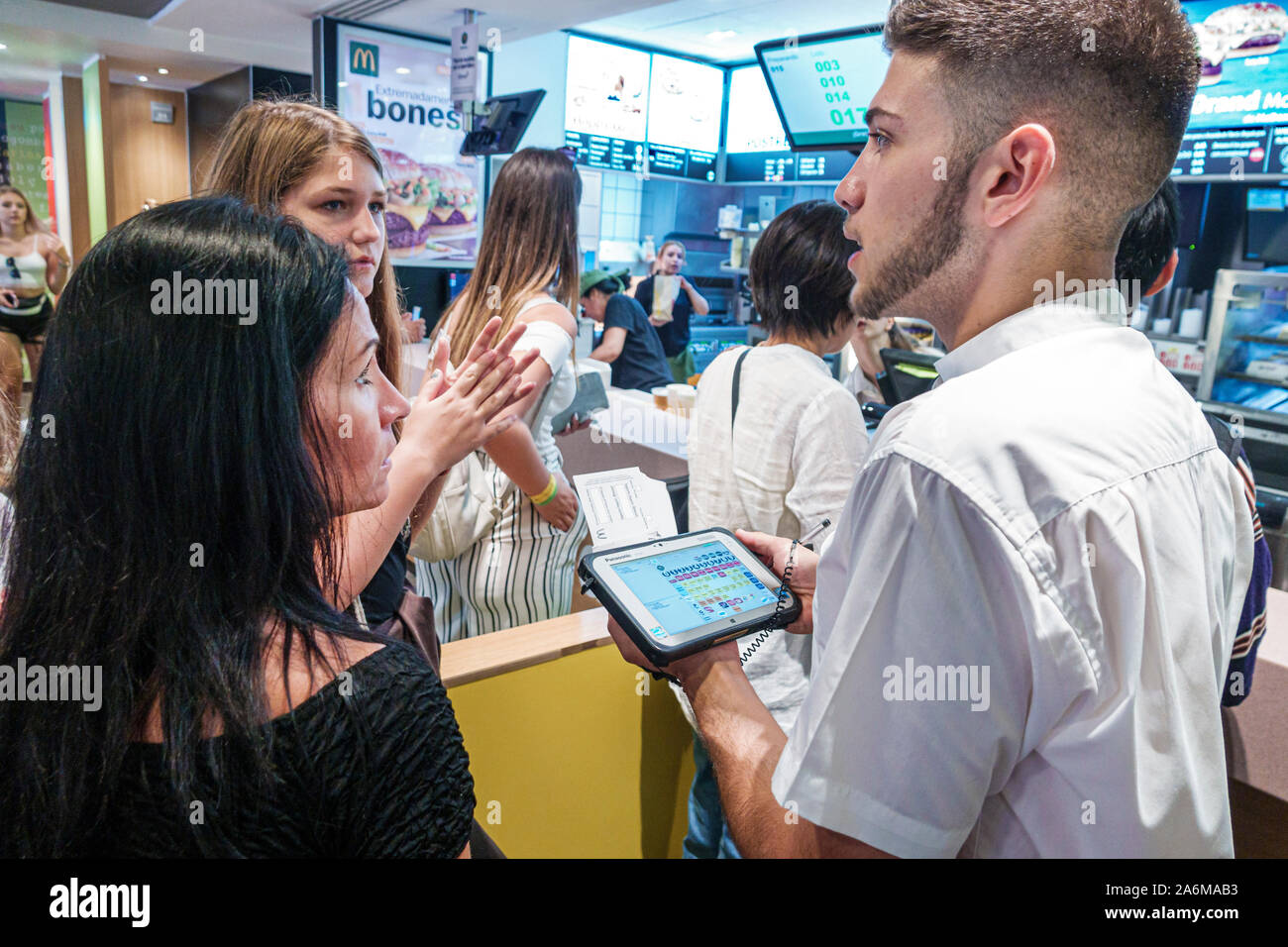 Barcelona Spanien,Catalonia Eixample,Sagrada Familia,McDonalds, Restaurant,Fast Food,mobiles iPad Bestellsystem,Frau,Mädchen,Teenager,Junge,Arbeiter,Essen nehmen Stockfoto