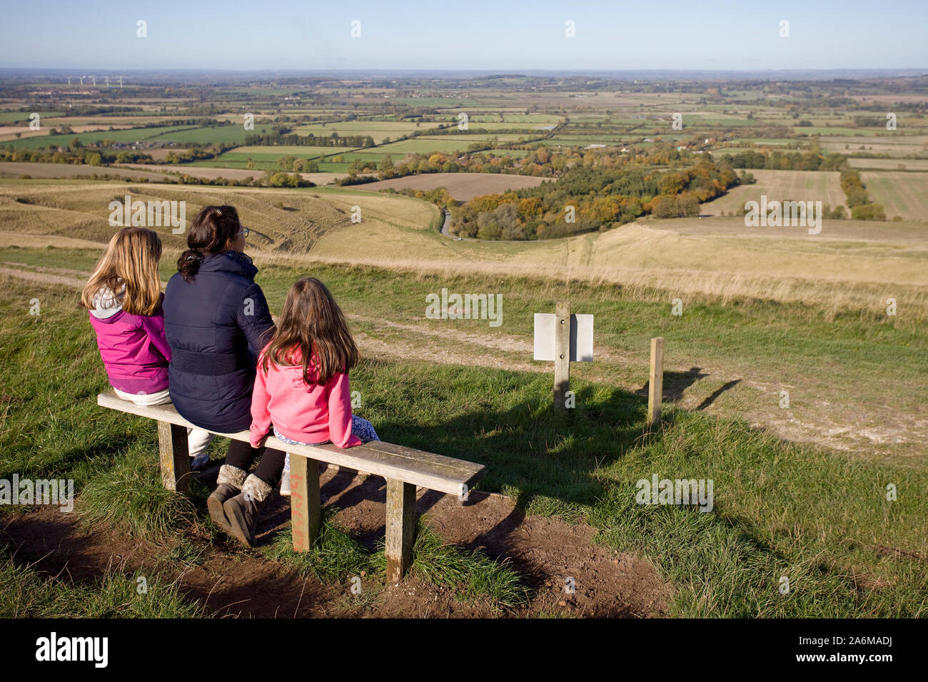 Mutter und Kinder saßen die Aussicht bewundern von Uffington White Horse Hill in Oxfordshire. England Stockfoto