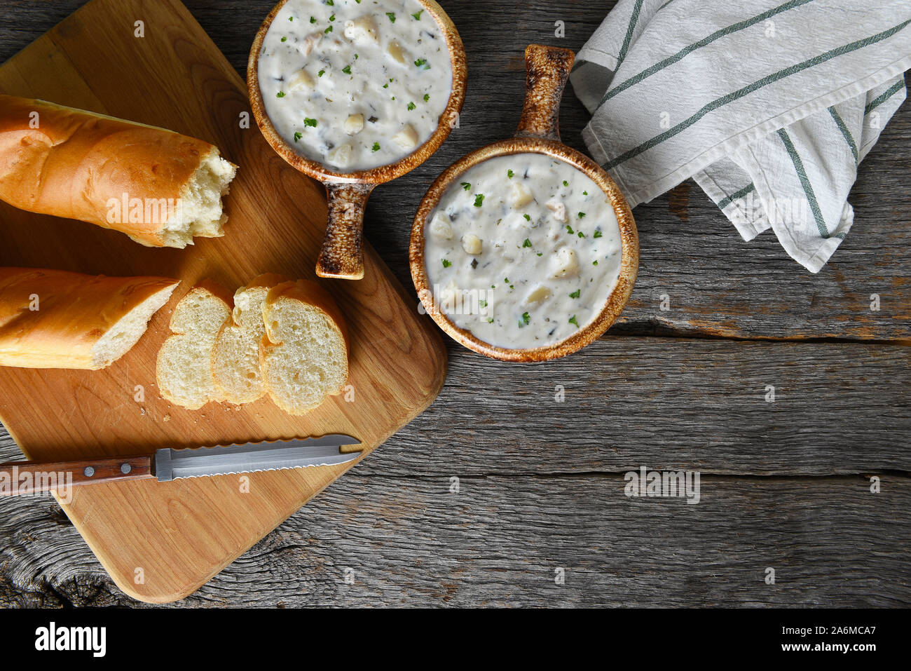 Blick von oben auf die zwei Schalen mit hausgemachten Clam Chowder mit frisch gebackenem Brot. Horizontal mit kopieren. Stockfoto