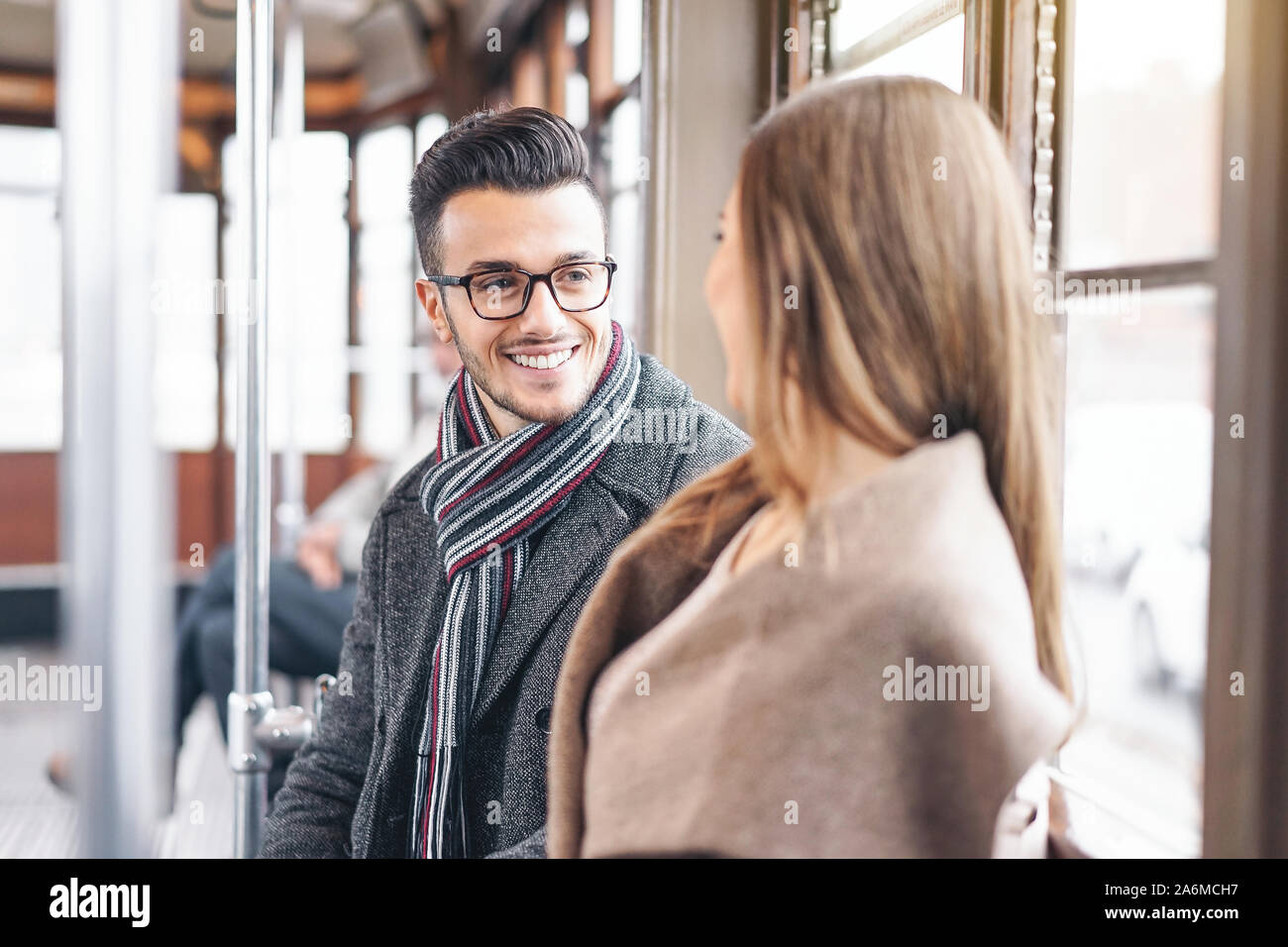 Junges Paar ein Gespräch beim Sitzen im Inneren vintage Straßenbahn - glückliche Menschen reden während der Fahrt in Bus city center Stockfoto