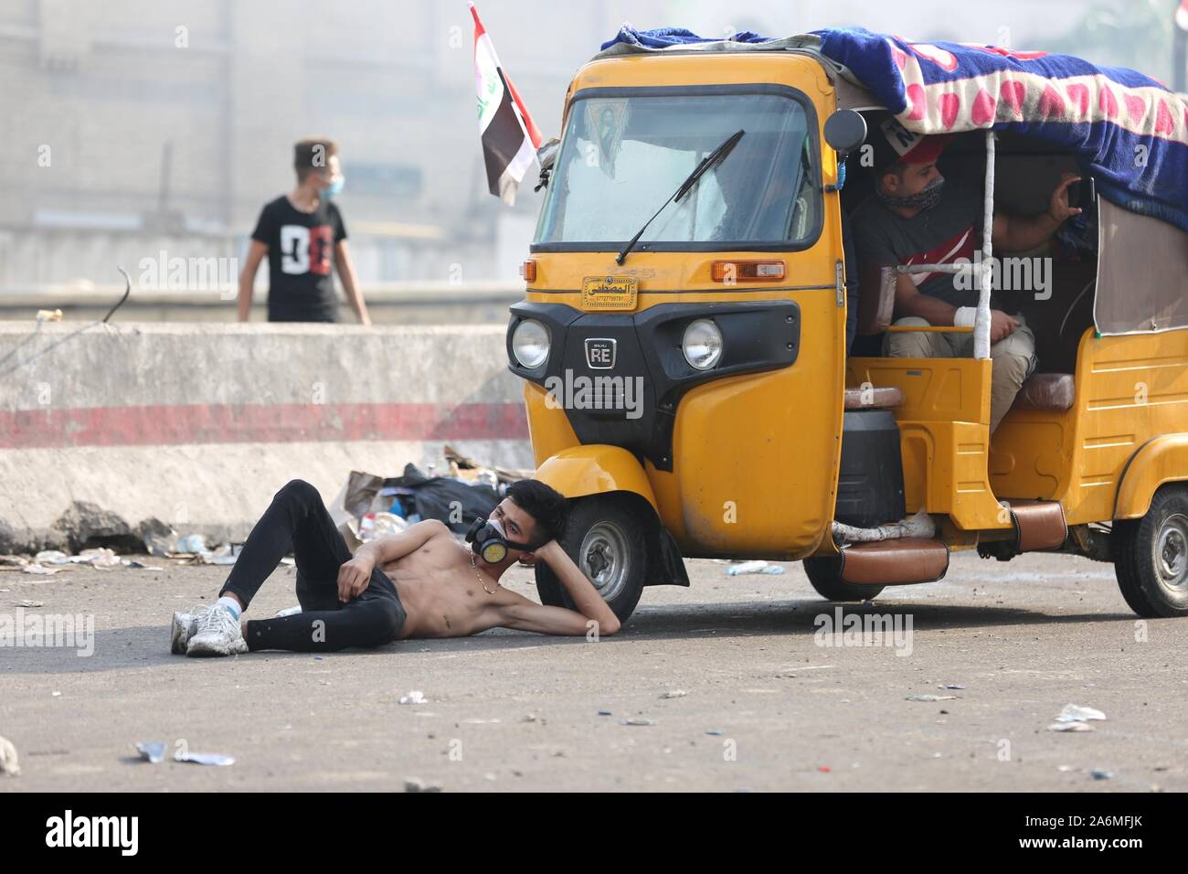 Bagdad, Irak. 27 Okt, 2019. Eine Demonstrantin nimmt einen Rest von einem Tuk-tuk während eines Protestes auf dem Tahrir Platz in Bagdad, Irak, am Okt. 27, 2019. Die irakische Regierung erklärte am Sonntag, dass die Zahl der Todesopfer von der neuen Welle der bundesweiten Proteste gegen Arbeitslosigkeit, Korruption und dem Mangel an öffentlichen Dienstleistungen auf 74 gestiegen ist, und mehr als 3.600 verletzt worden. Quelle: Khalil Dawood/Xinhua/Alamy leben Nachrichten Stockfoto