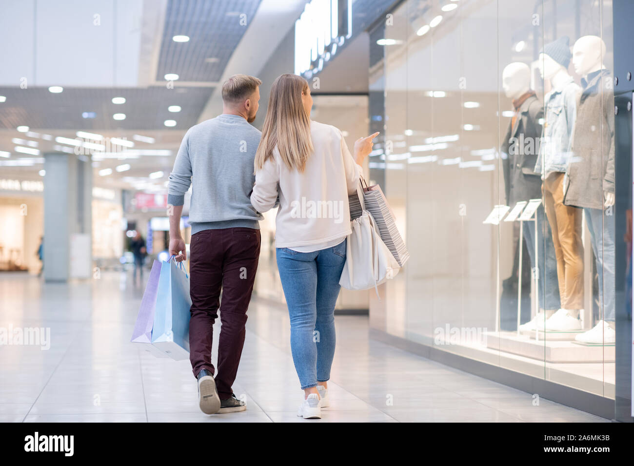 Zurück Blick auf junge Käufer die Aufmerksamkeit auf neue männliche Casual Wear Kollektion Stockfoto
